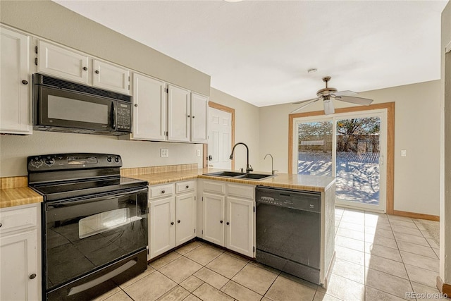 kitchen with black appliances, kitchen peninsula, sink, light tile patterned flooring, and white cabinetry