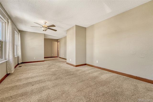 unfurnished room featuring a textured ceiling, light colored carpet, and ceiling fan