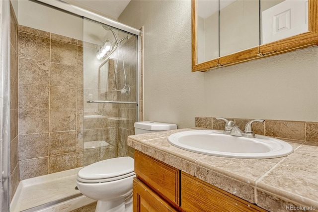 bathroom featuring vanity, toilet, and an enclosed shower