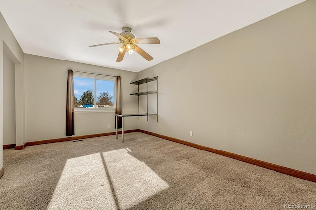 carpeted spare room featuring ceiling fan