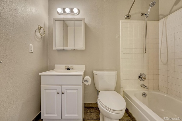 full bathroom with toilet, vanity, and tiled shower / bath