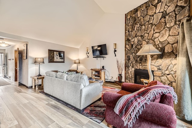 325 Four O Clock Rd Unit 303, Breckenridge, CO 80424 - living area with light wood-type flooring, a stone fireplace, and lofted ceiling