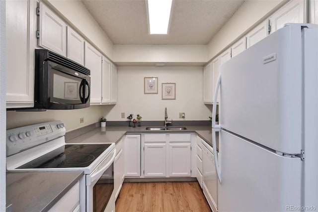 kitchen with white cabinetry, sink, white appliances, and light hardwood / wood-style flooring