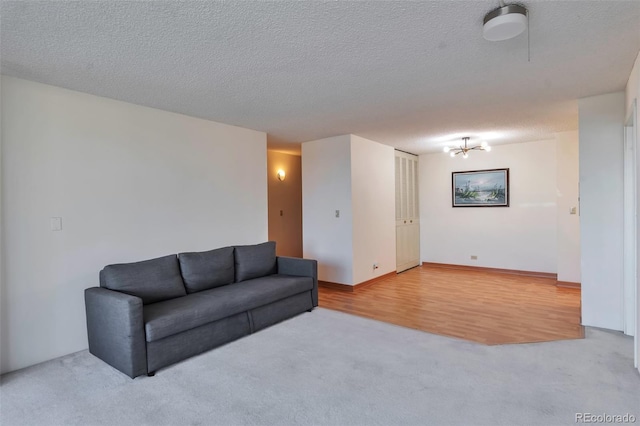 living room with a textured ceiling, carpet floors, and an inviting chandelier