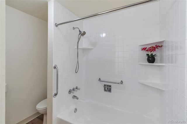 bathroom featuring tiled shower / bath combo and toilet