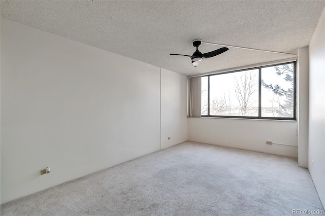 carpeted spare room with ceiling fan and a textured ceiling