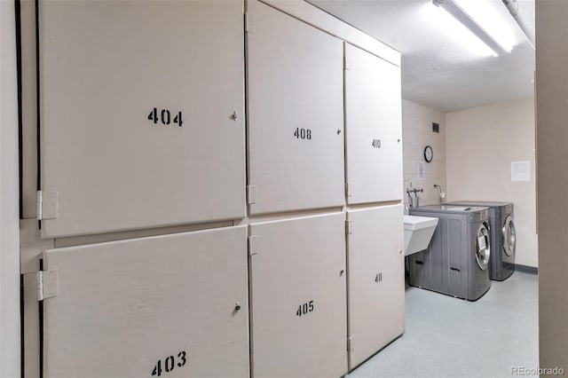 laundry area with separate washer and dryer and a textured ceiling