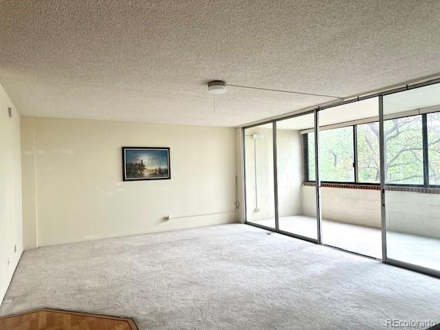 1850 Folsom St Unit 411, Boulder, CO 80302 - unfurnished bedroom with carpet floors, a textured ceiling, and a wall of windows