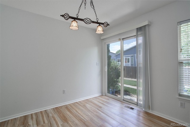 unfurnished room featuring light hardwood / wood-style flooring and a healthy amount of sunlight