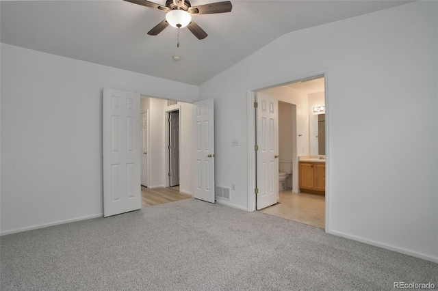 unfurnished bedroom featuring ensuite bathroom, ceiling fan, lofted ceiling, and light colored carpet