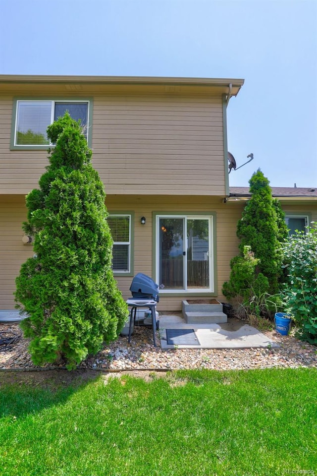 back of house featuring a patio area and a lawn