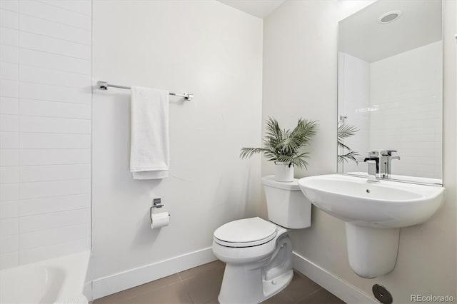 bathroom featuring toilet, tile patterned flooring, and a bathing tub