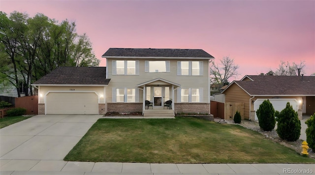 1055 Lindstrom Dr, Colorado Springs, CO 80911 - colonial inspired home with an attached garage, driveway, and brick siding