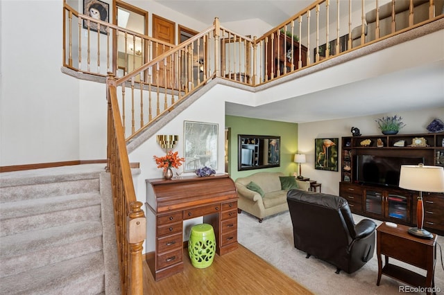 1055 Lindstrom Dr, Colorado Springs, CO 80911 - living area with stairs, a high ceiling, baseboards, and carpet flooring