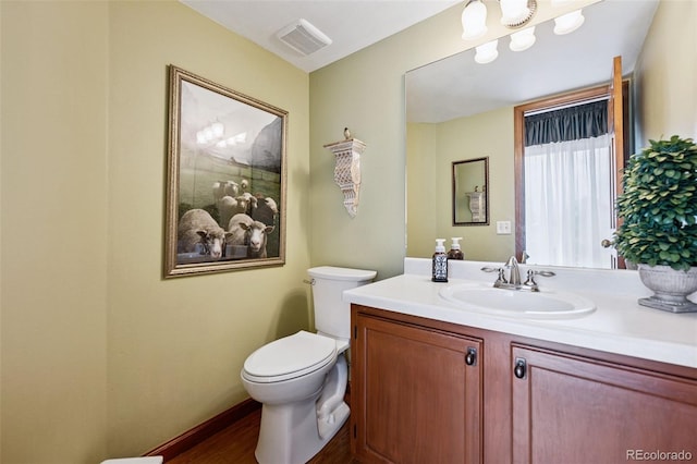 1055 Lindstrom Dr, Colorado Springs, CO 80911 - bathroom with toilet, vanity, wood finished floors, and baseboards