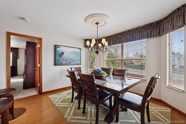 1055 Lindstrom Dr, Colorado Springs, CO 80911 - dining space with a chandelier, healthy amount of natural light, light wood-style flooring, and baseboards