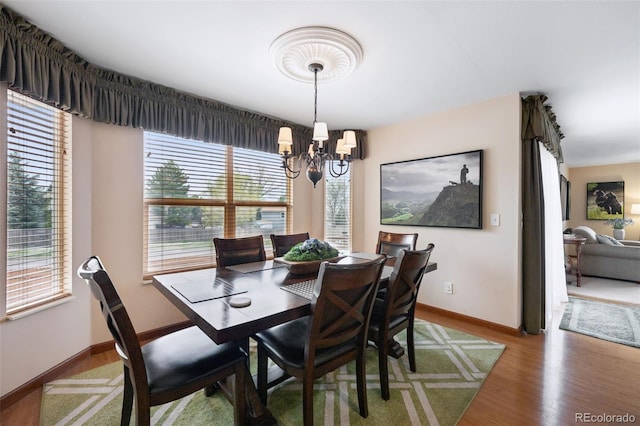 1055 Lindstrom Dr, Colorado Springs, CO 80911 - dining area featuring a chandelier, wood finished floors, and baseboards