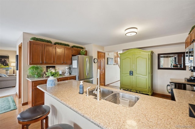 1055 Lindstrom Dr, Colorado Springs, CO 80911 - kitchen featuring appliances with stainless steel finishes, a sink, brown cabinets, and light stone counters