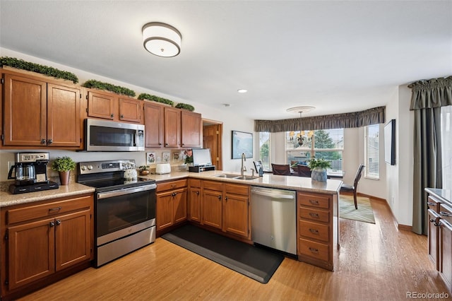 1055 Lindstrom Dr, Colorado Springs, CO 80911 - kitchen with stainless steel appliances, a peninsula, light wood finished floors, a sink, and recessed lighting