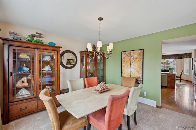 1055 Lindstrom Dr, Colorado Springs, CO 80911 - dining room featuring a chandelier, light colored carpet, and baseboards