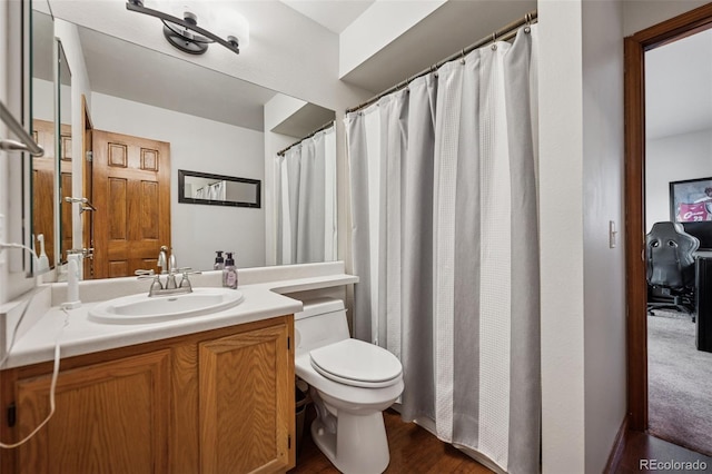 1055 Lindstrom Dr, Colorado Springs, CO 80911 - bathroom with toilet, vanity, and wood finished floors