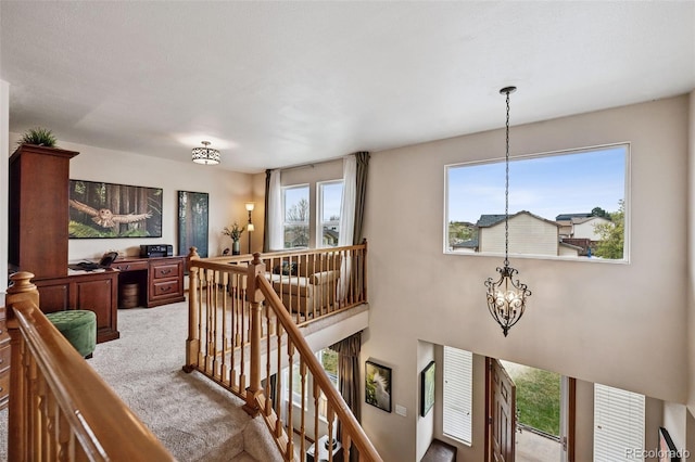 1055 Lindstrom Dr, Colorado Springs, CO 80911 - stairway featuring a chandelier, carpet, and healthy amount of natural light