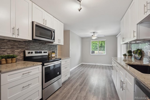 3685 Lewis St, Wheat Ridge, CO 80033 - kitchen featuring appliances with stainless steel finishes, baseboards, tasteful backsplash, white cabinets, and a ceiling fan