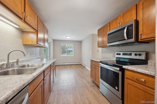 3685 Lewis St, Wheat Ridge, CO 80033 - kitchen with appliances with stainless steel finishes, a sink, light wood finished floors, light countertops, and brown cabinetry