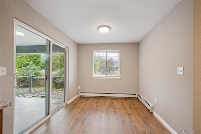 3685 Lewis St, Wheat Ridge, CO 80033 - empty room featuring a baseboard radiator, light wood-style flooring, baseboards, and baseboard heating