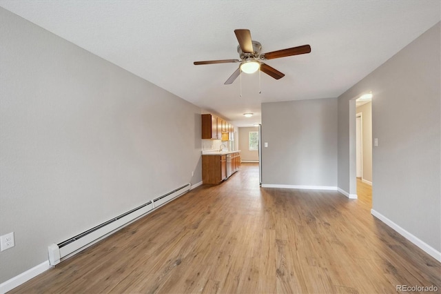 3685 Lewis St, Wheat Ridge, CO 80033 - unfurnished living room with a baseboard heating unit, ceiling fan, light wood-type flooring, and baseboards