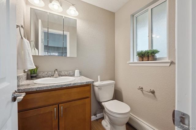 3685 Lewis St, Wheat Ridge, CO 80033 - bathroom with toilet, vanity, a baseboard heating unit, and a textured wall