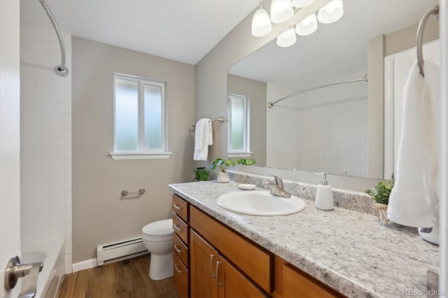 3685 Lewis St, Wheat Ridge, CO 80033 - bathroom featuring a baseboard heating unit, wood finished floors, toilet, vanity, and tub / shower combination