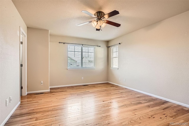 unfurnished room with a textured ceiling, light hardwood / wood-style floors, and ceiling fan