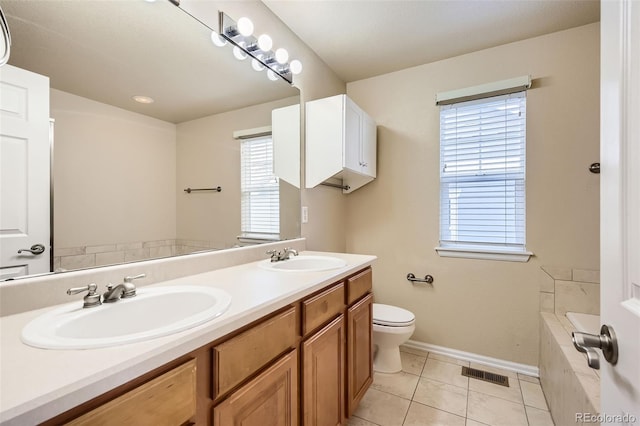 bathroom with tile patterned flooring, vanity, a healthy amount of sunlight, and a washtub