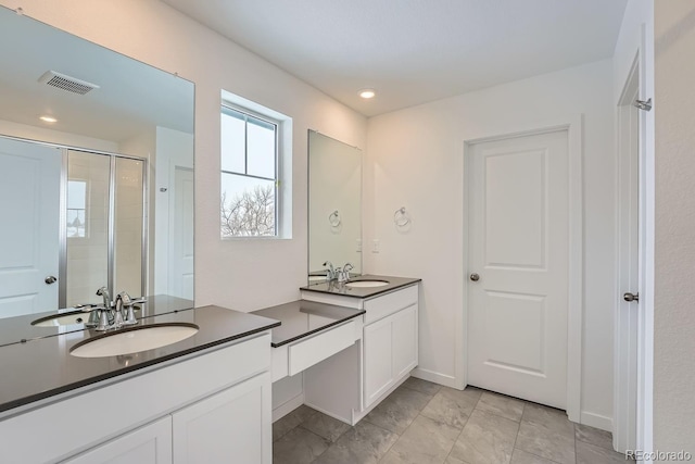 bathroom with a shower with door and vanity