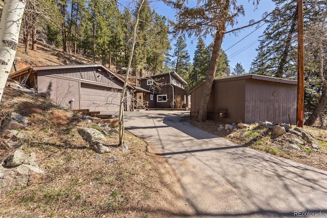 10179 S Turkey Creek Rd, Morrison, CO 80465 - view of front facade featuring driveway, an outbuilding, and an attached garage
