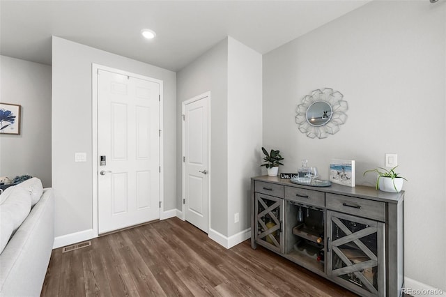 entryway featuring wood finished floors, baseboards, and recessed lighting