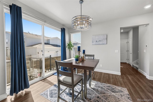 dining space featuring a chandelier, wood finished floors, baseboards, and recessed lighting