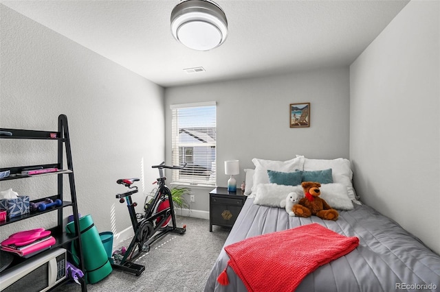 bedroom with carpet floors, baseboards, and a textured wall