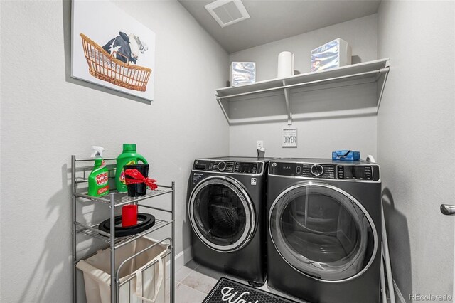 washroom with washing machine and dryer and tile patterned floors