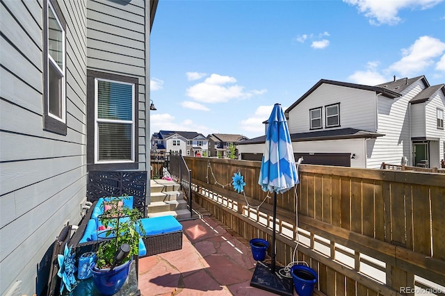 view of patio featuring fence and a residential view