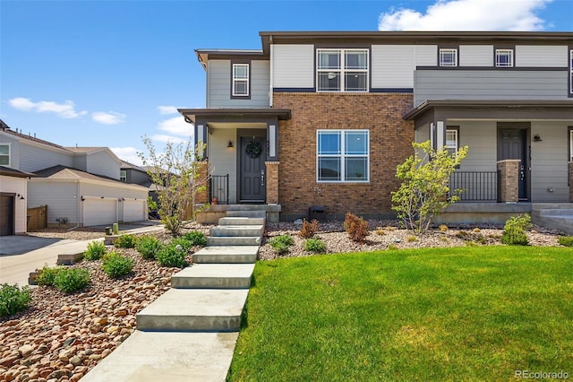 4581 S Kipling Cir, Denver, CO 80123 - view of front of home featuring brick siding, a front yard, and covered porch