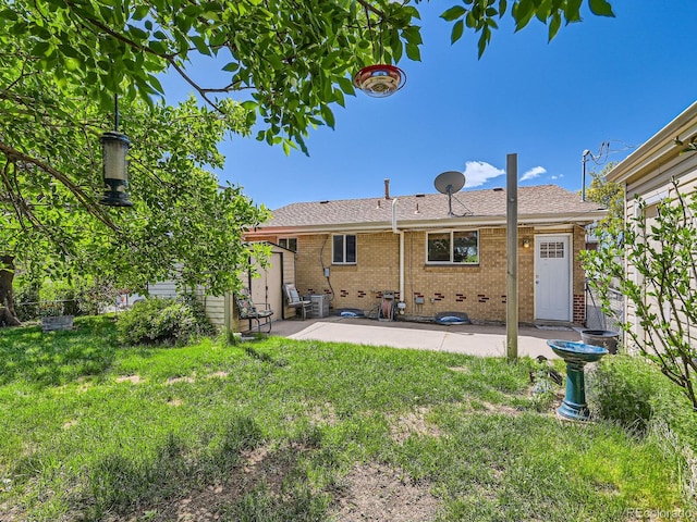 3531 E 91st Ave, Thornton, CO 80229 - rear view of house with a patio area, brick siding, and a lawn