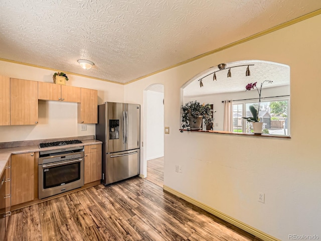 3531 E 91st Ave, Thornton, CO 80229 - kitchen with appliances with stainless steel finishes, a textured ceiling, dark wood-style flooring, light countertops, and arched walkways