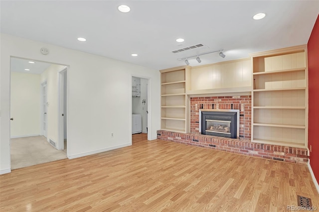 unfurnished living room featuring recessed lighting, a fireplace, visible vents, and light wood-style floors