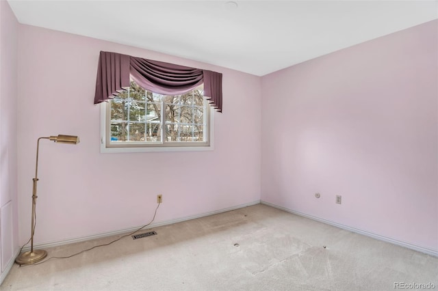 spare room with carpet flooring, visible vents, and baseboards