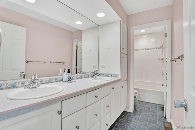 bathroom with double vanity, tile patterned flooring, a sink, and toilet