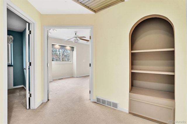 corridor featuring carpet floors, visible vents, and baseboards