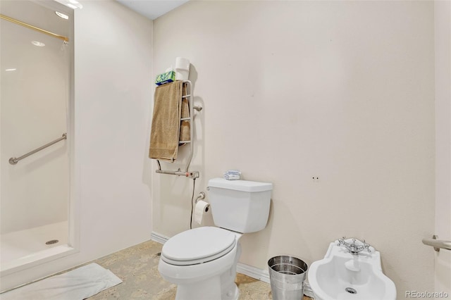 bathroom featuring a bidet, a shower stall, toilet, and baseboards