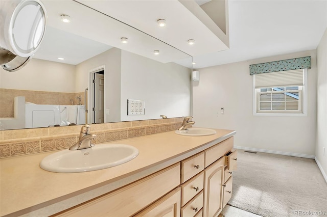 bathroom with a shower, a sink, baseboards, and double vanity